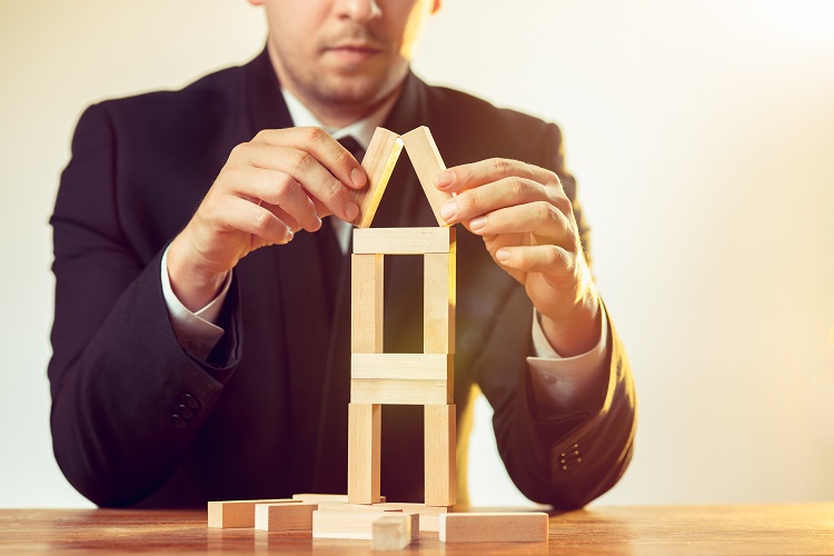 Man and wooden cubes on table. Management and marketing concepts